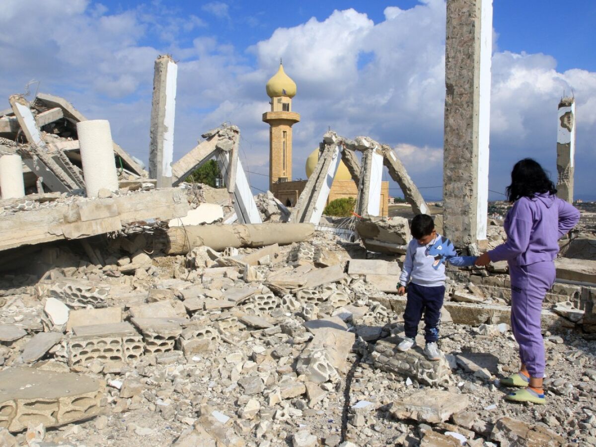 Crianças caminham entre os escombros de uma igreja na vila de Derdghaya, no sul do Líbano, mais de um mês depois de ela ter sido parcialmente destruída por um ataque aéreo israelense