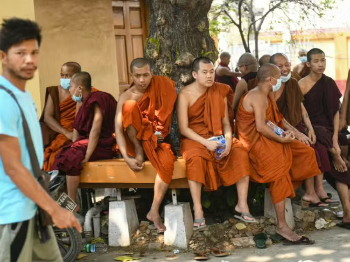 Monges esperam durante operações de busca e resgate em templo danificado em Mandalay, Mianmar