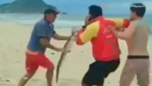 Homem ameaça banhista com um jacaré em praia no Rio