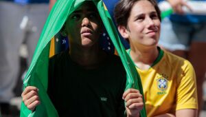 Com sombrinha e bandeira para aliviar o sol, torcida acompanha jogo do Brasil no Cais da Alfândega