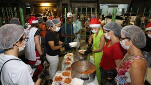 Em clima de Natal, pessoas em situação de rua recebem jantar no Recife