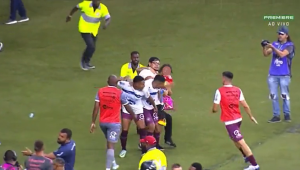 Com criança no colo, torcedor do Inter invade o gramado para agredir jogador adversário; assista
