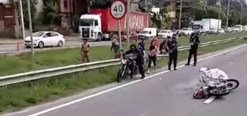 Passageira morre em acidente de moto após condutor de aplicativo passar entre carretas na BR-101