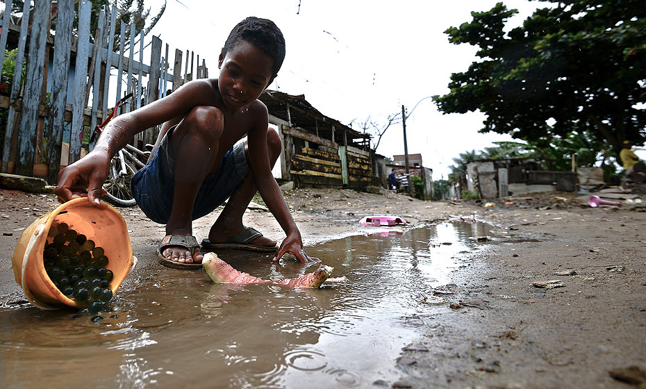 Criança brinca em rua de comunidade vizinha ao rio Tejipió