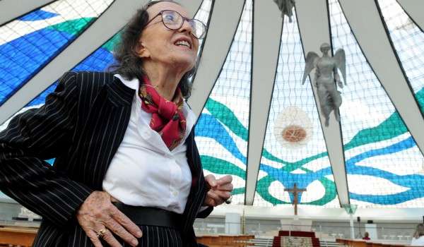 Marianne na catedral de Brasília, ao fundo os vitrais, criados por ela