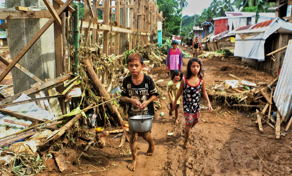 Crianças andam por casas daificadas nas Filipinas