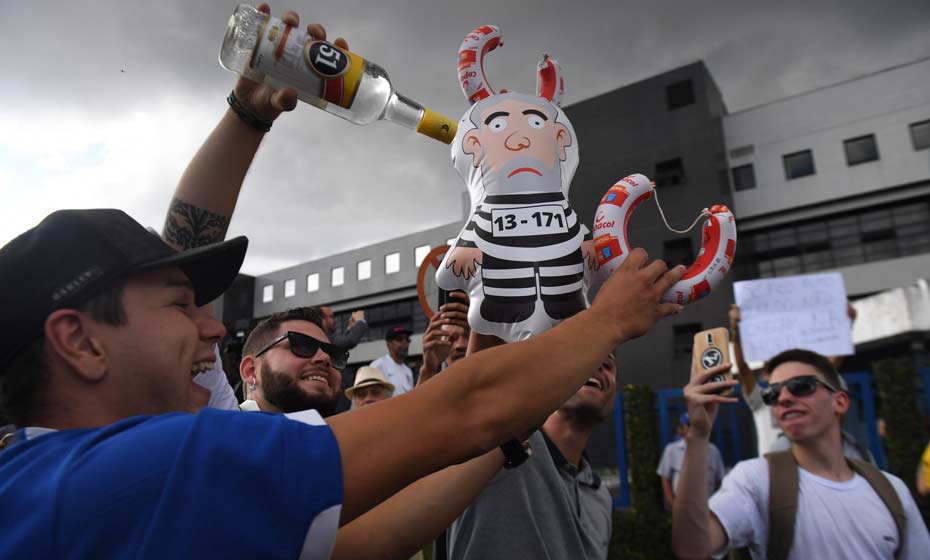 Em Curitiba, manifestante representa boneco de Lula preso junto com garrafa da cachaça 51, cujo slogan era "Uma boa ideia"