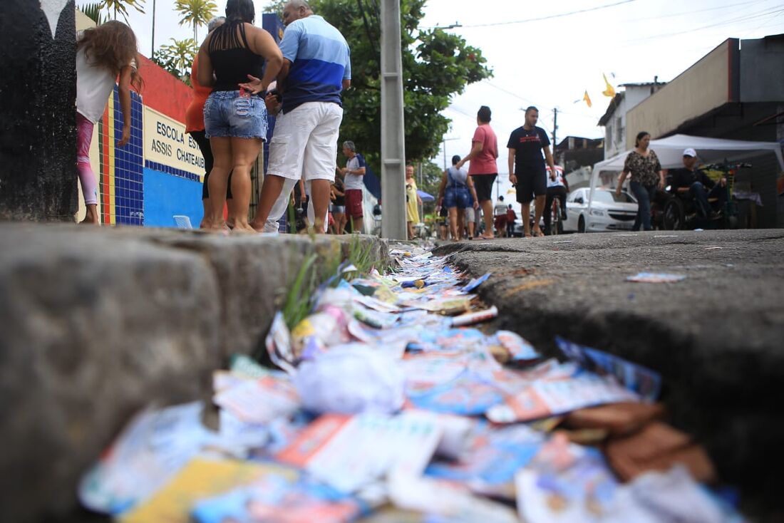 Muitos santinhos espalhados no chão em frente à Escola Assis Chateaubriand, em Brasília Teimosa