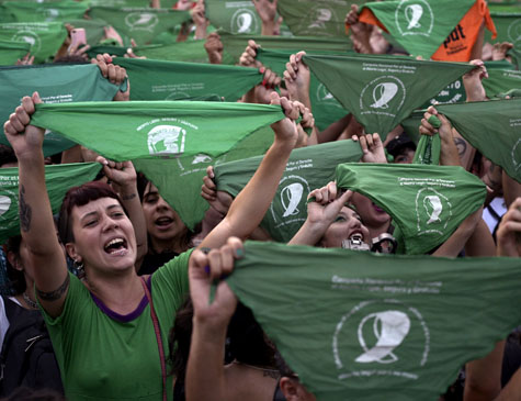 Ativistas levantam lenços verdes exigindo a legalização do aborto legal