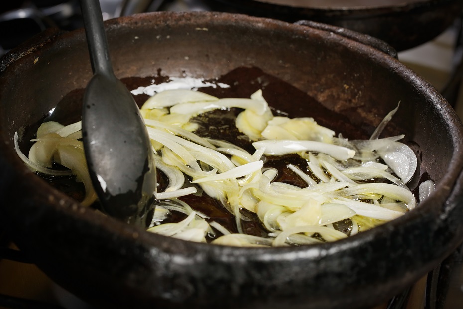 Em uma panela de barro, coloque azeite e doure levemente a cebola e o alho
