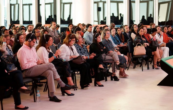 Na Conferência Ethos 360º, os participantes utilizam fones para ouvir aos painéis