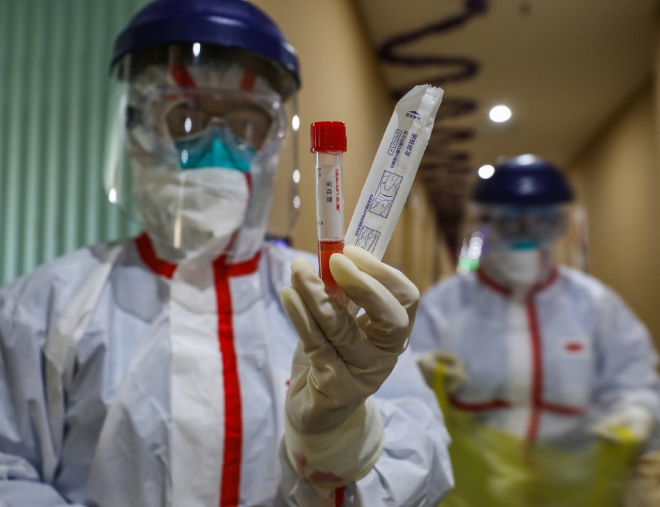 Agentes de saúde em zona de quarentena, em Wuhan, epicentro da epidemia