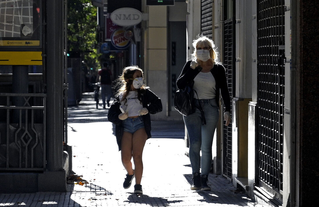 Pessoas caminham de máscaras pelas ruas de Buenos Aires