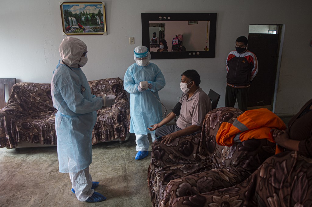 Médicos visitam paciente com a Covid-19 no Peru