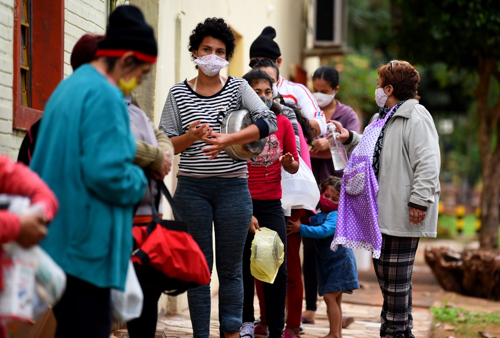 Pessoas fazem fila para receber refeição em Itá, no Paraguai