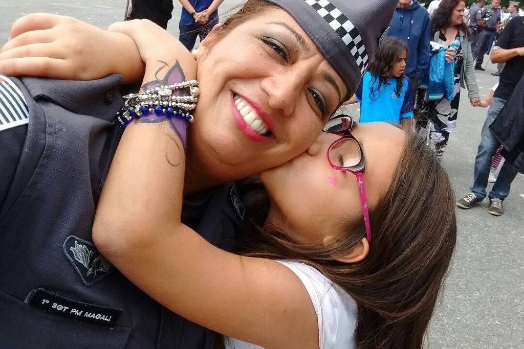 A policial militar Magali Garcia, 46, uma das vítimas Covid-19, recebe beijo da filha, Ana Júlia, durante solenidade