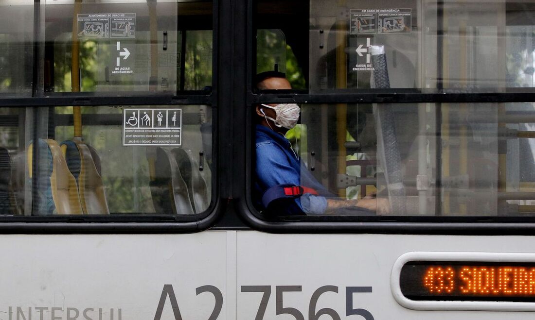 Homem de máscara sentado no ônibus