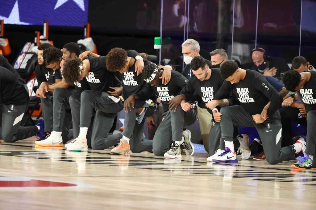 Jogadores de Utah Jazz e New Orleans Pelicans ajoelhados durante execução do hino dos EUA