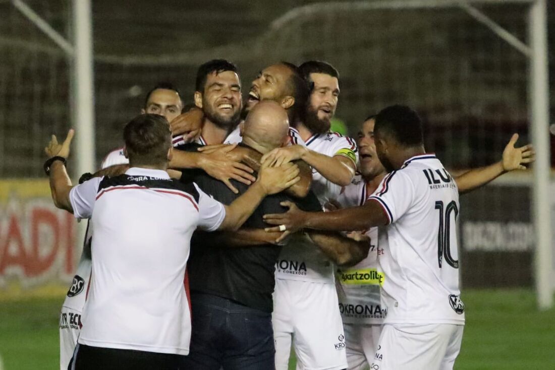 Jogadores comemoram o gol abraçados ao técnico Itamar Schülle