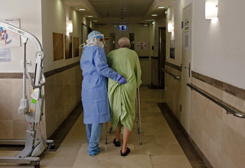 Enfermeiro ajuda paciente em hospital de Tel-Aviv, em Israel