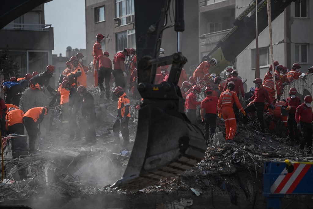 Bombeiros vasculham escombros em terremoto no distrito de Bayrakli, em Esmirna, na Turquia.