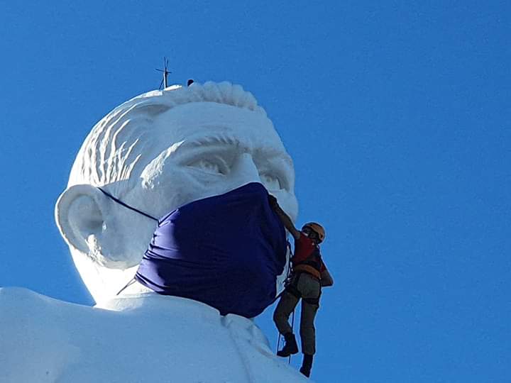 Bombeiro coloca máscara facial na estátua do Padre Cícero