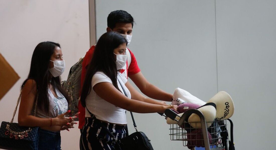 Pessoas usando máscara no aeroporto