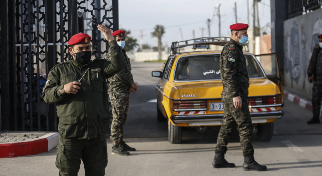 Membros das forças de segurança palestinas leais ao Hamas montam guarda na fronteira de Rafah com o Egito, no sul da Faixa de Gaza, enquanto veículos passam deixando a Faixa de Gaza