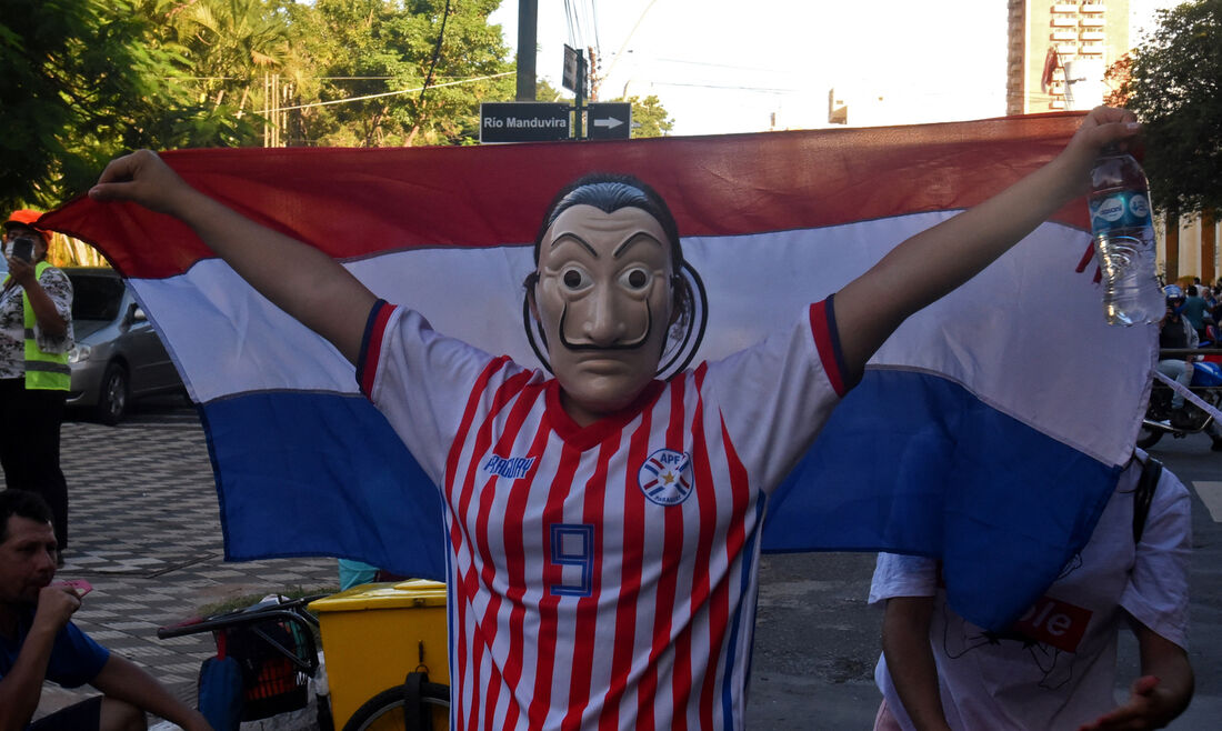 Um manifestante com uma máscara de Dali da série espanhola de sucesso da Netflix, La Casa de Papel, segura uma bandeira paraguaia durante um protesto exigindo a renúncia do presidente paraguaio, Mario Abdo Benitez