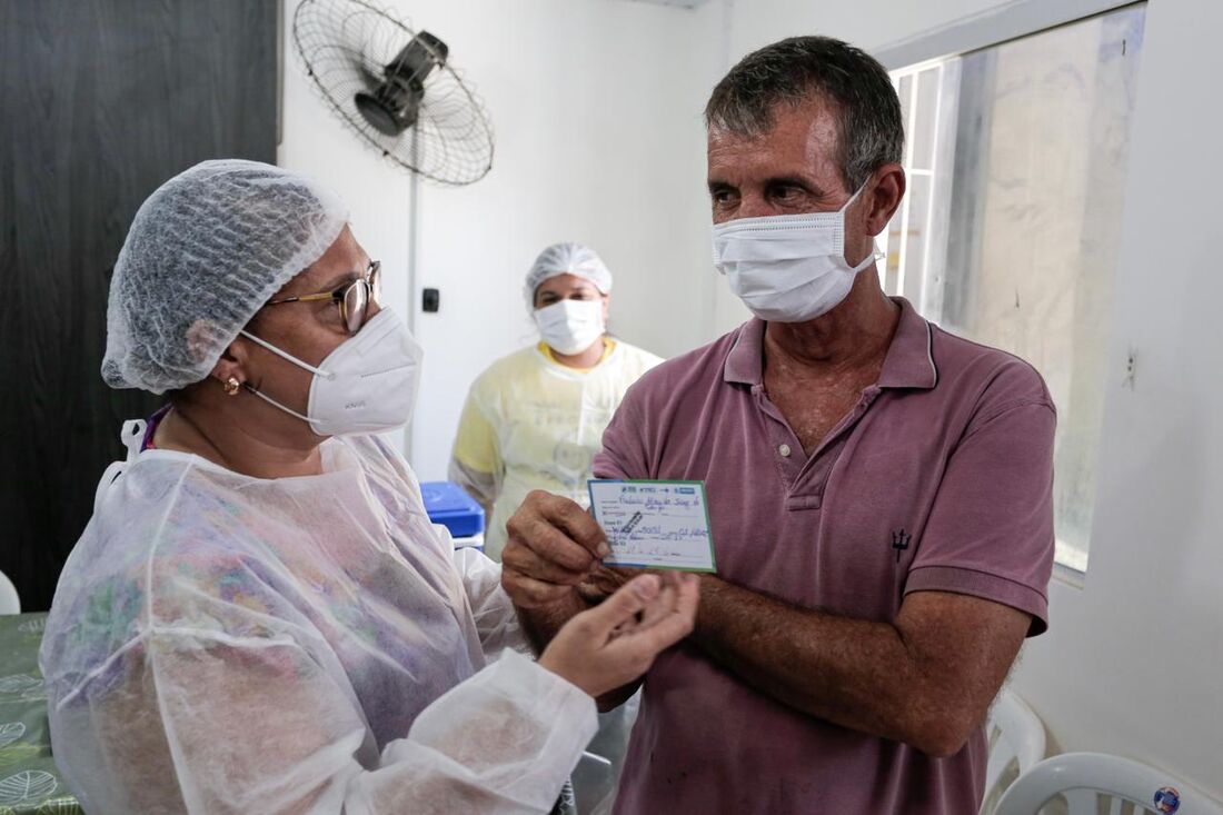 Frederico Almeida, 60 anos e morador de rua, recebe cartão de vacinação