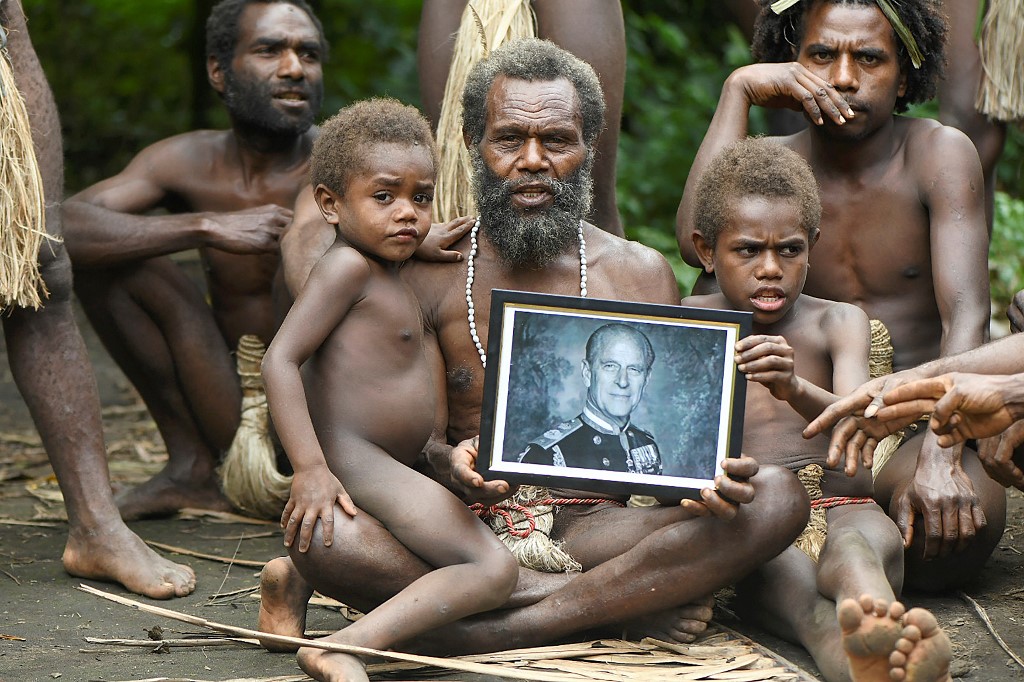 Chefe da aldeia segura retrato de Philip ao lado de membros da sua família