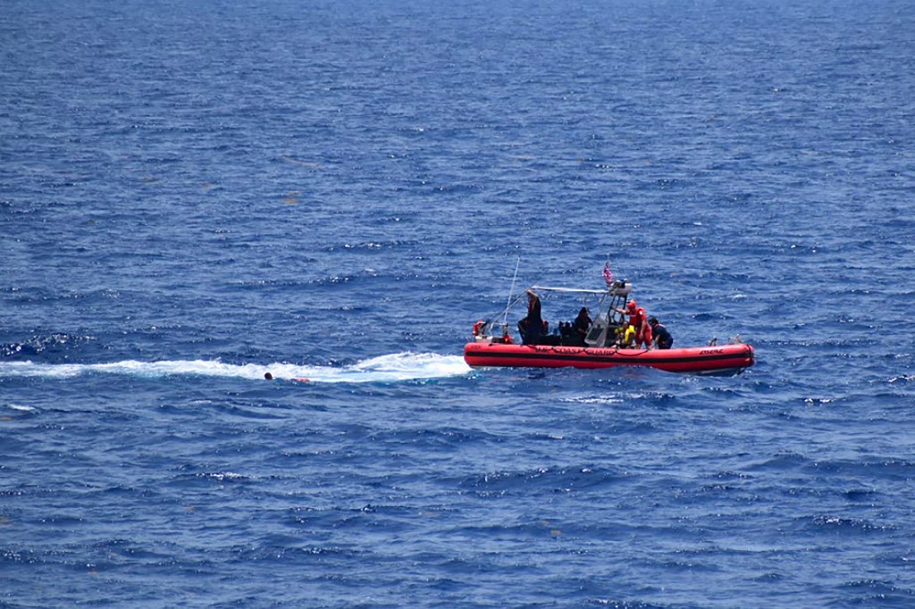 Pequeno barco da Guarda Costeira tenta resgatar pessoas da água a aproximadamente 18 milhas a sudoeste de Key West, Flórida