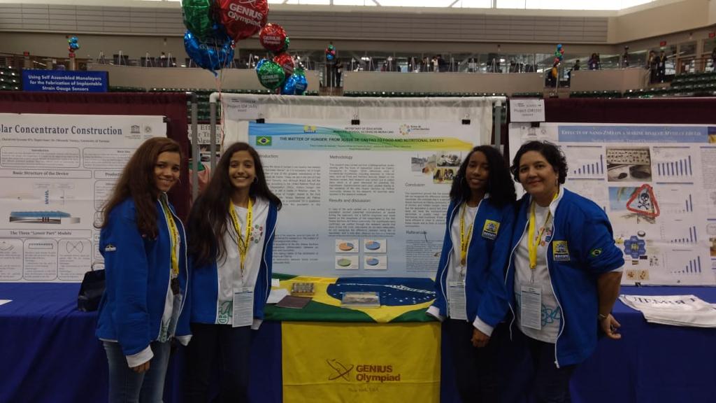 Professora Ana Paula junto com estudantes apresentando trabalho em feira em Nova York