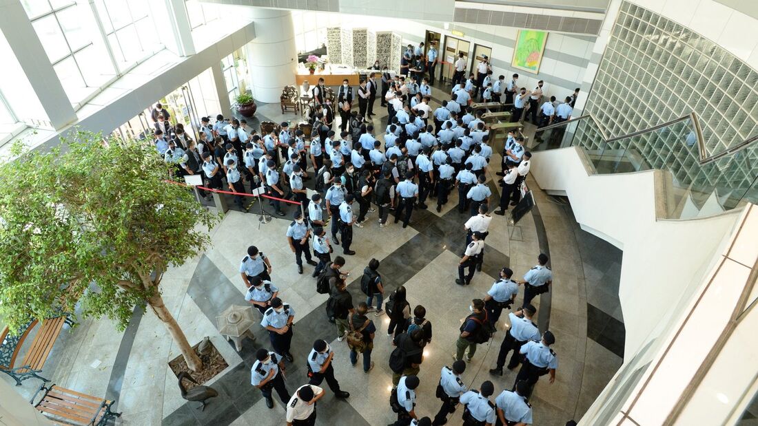 Policiais reunidos na sede do jornal Apple Daily em Hong Kong