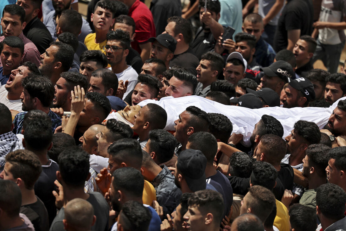 Enlutados carregam o corpo do adolescente palestino Ahmed Zahi Dawoud, morto por forças israelenses