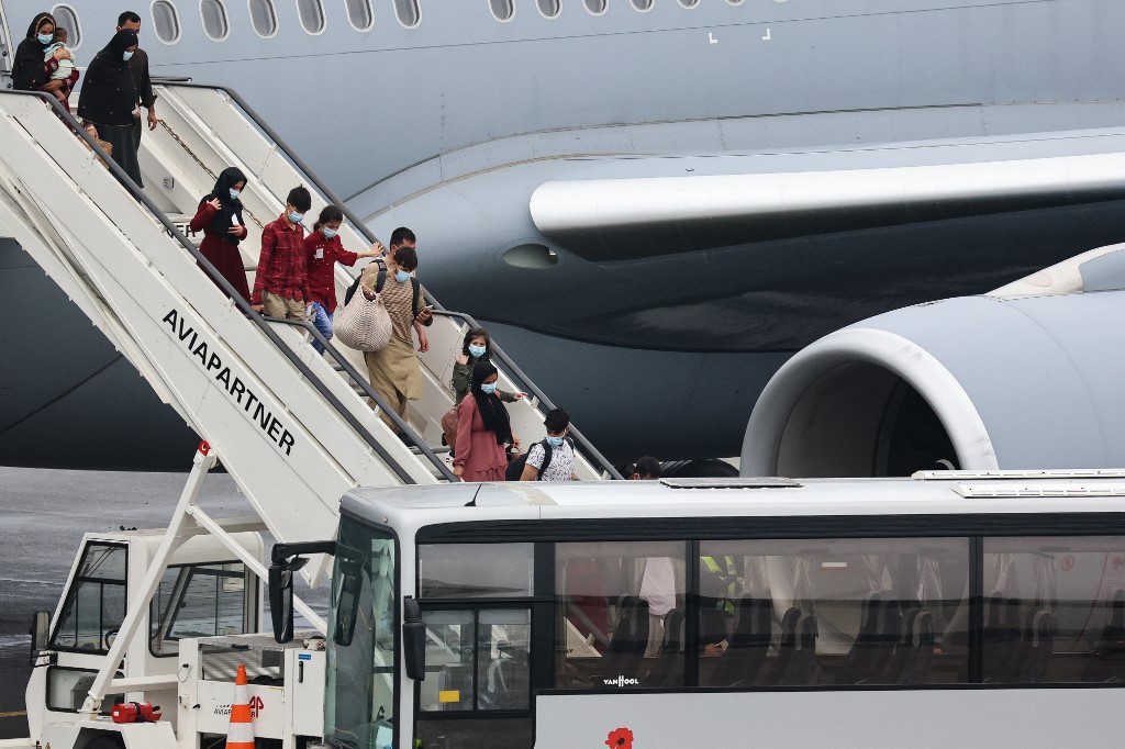 Grupo de cidadãos afegãos depois de desembarcar de um avião militar