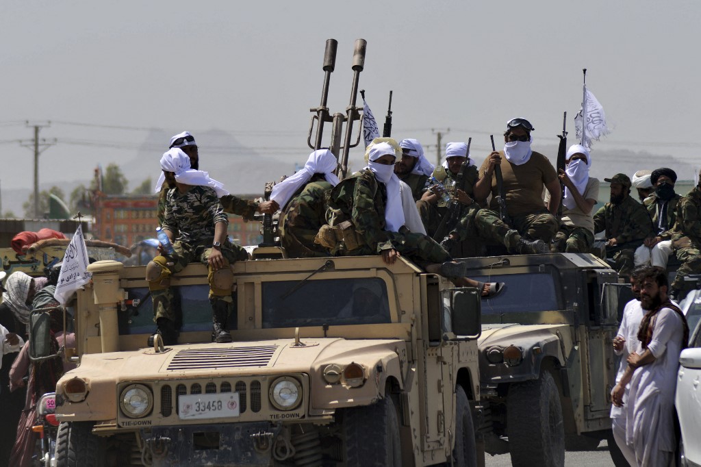 Soltados do Taleban em seu veículo militar celebrando a saída das tropas dos Estados Unidos do solo afegão.