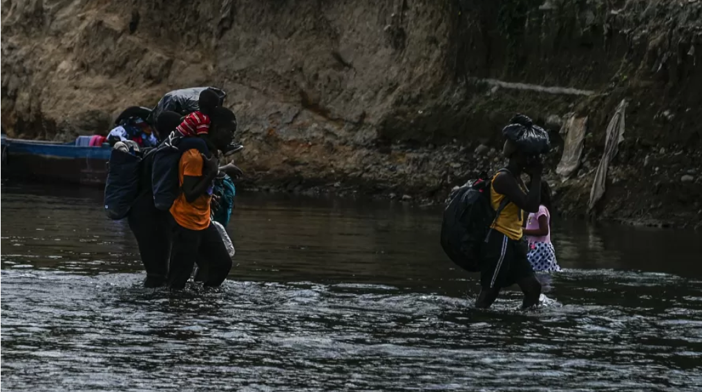 Migrantes haitianos e de vários países africanos cruzam o rio Chucunaque, na província de Darien, Panamá