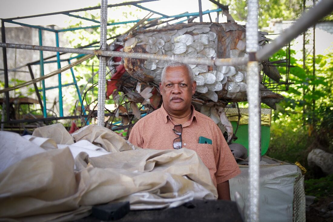 Aldo Alexandre, presidente da Gigante do Samba, entre os materiais deteriorados