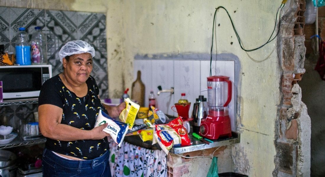 Rita Maria de Souza, 59 anos, abre a cesta básica que ganhou da campanha Natal sem Fome 