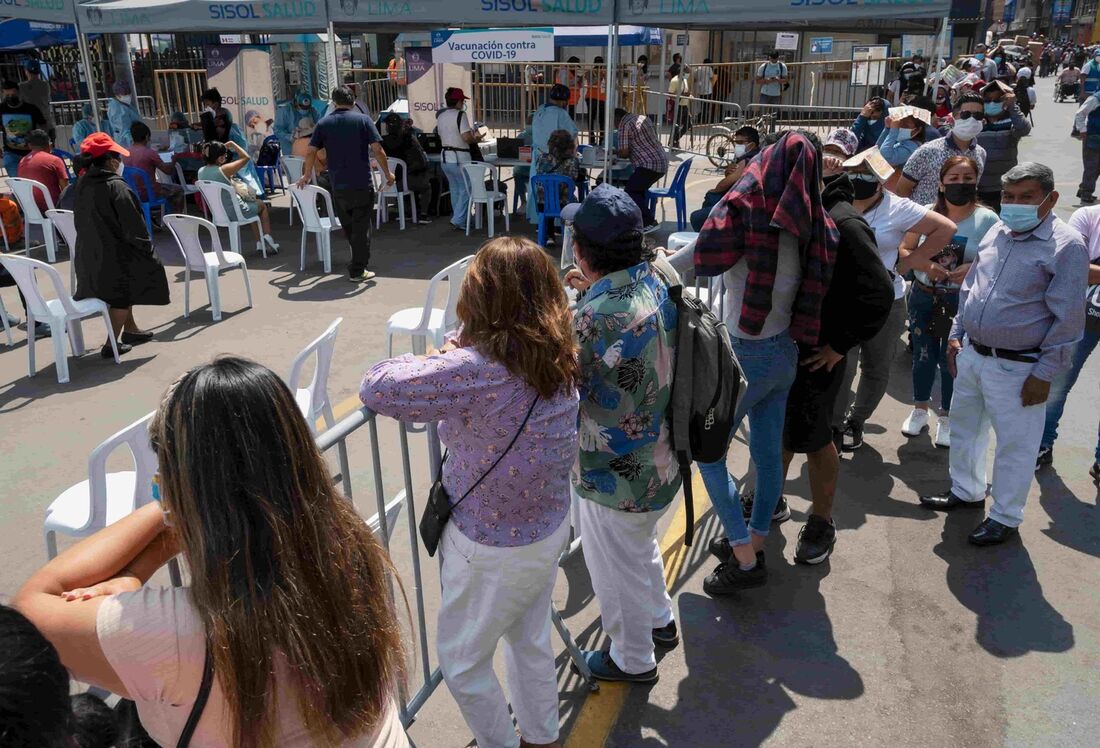 Pessoas fazem fila para um teste molecular gratuito e para serem vacinadas em um posto de saúde improvisado em uma rua no centro de Lima em 5 de janeiro de 2022