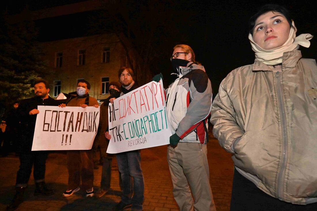 Ativistas seguram cartazes "Sem ditadura, sim solidariedade!" e "Liberdade!" fora da embaixada do Cazaquistão em Kiev em 6 de janeiro de 2022 durante uma ação em apoio aos manifestantes no Cazaquistão e pedindo o fim da intervenção militar da Rússia