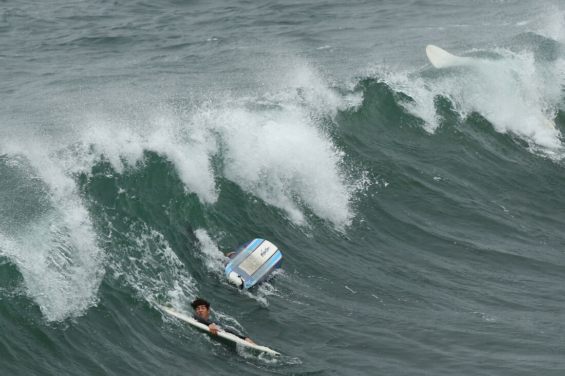 Surfista com suas pranchas de surfe em Manhattan Beach, Califórnia. Foram emitidos alertas de tsunami para toda a costa oeste dos EUA