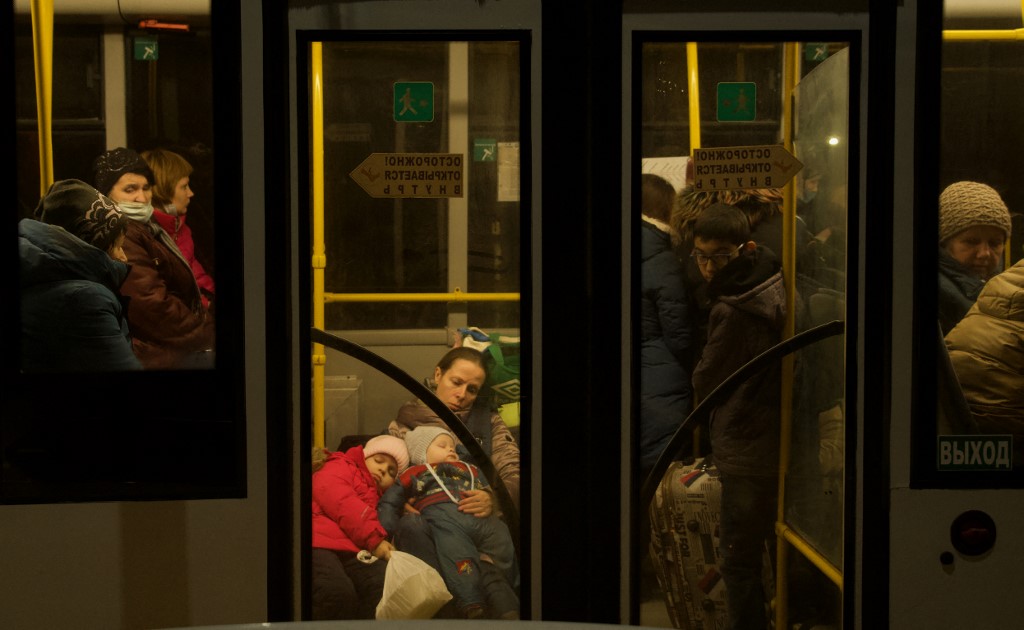 Pessoas evacuadas da autoproclamada República Popular de Donetsk sentadas em um ônibus esperando que seu trem seja evacuado para as profundezas da Rússia, na cidade de Taganrog, em 20 de fevereiro de 2022