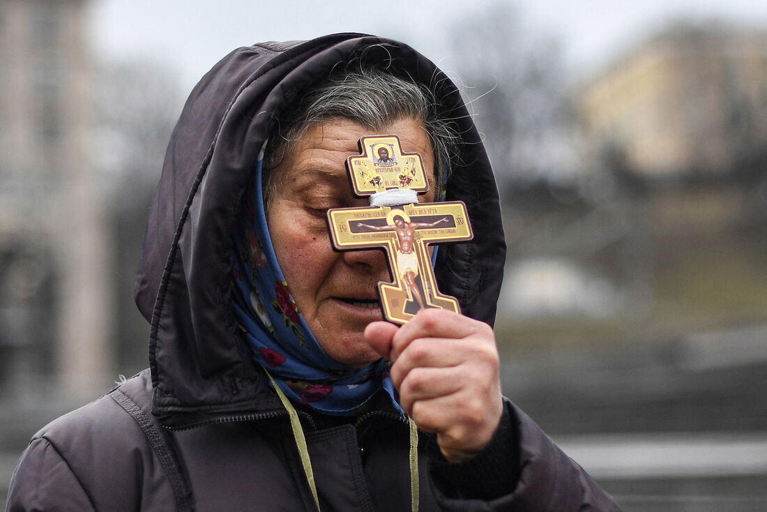 Mulher rezando na Praça da Independência em Kiev, na Ucrânia