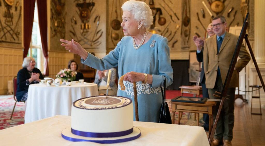 Rainha Elizabeth diante do bolo do Jubileu de Platina