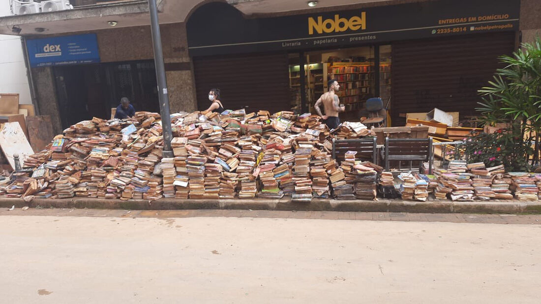 Encharcados e amarelados, livros foram colocados sobre calçada em frente à livraria