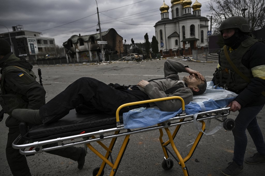 O soldado ucraniano Andriy Yermolayev, 50, que perdeu parte de sua perna durante o bombardeio russo em 24 de fevereiro, é evacuado da cidade de Irpin, a oeste de Kiev, em 7 de março de 2022