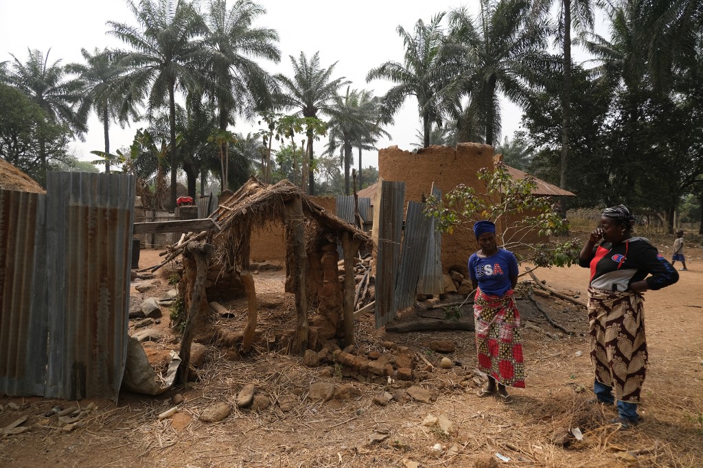 Parentes do falecido chefe de Manga Village, reagem do lado de fora de sua casa queimada em Manga, uma vila que faz fronteira com a Nigéria e Camarões, em 28 de janeiro de 2022