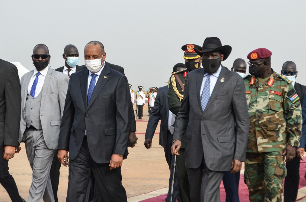 O presidente do Sudão do Sul Salva Kiir (2&ordm; à direita) caminha com o chefe do Conselho Soberano do Sudão, general Abdel Fattah al-Burhan (2&ordm; à esquerda) na chegada de Al-Burhan de Uganda ao Aeroporto Internacional de Juba em Juba, Sudão do Sul, 